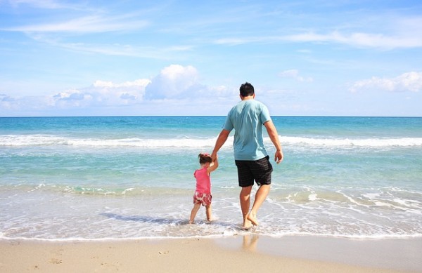 dad walking with small daughter in the surf