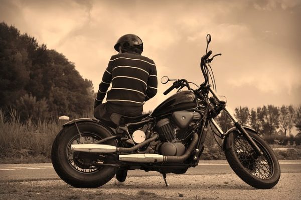 man setting on sideways on motorcycle